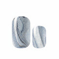 Pair of blue and white marbled nail art stickers on a white background