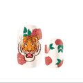 Nail art design with a tiger face and roses on a white background